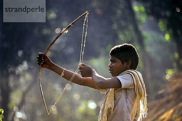 Jenu Kurumba Stammesjunge beim Zielen mit einem Stein  Nagarahole  Karnataka  Südindien  Indien  Asien