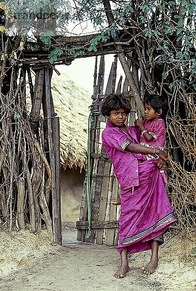 Ein Stammesmädchen mit ihrer Schwester  die sich an ihrer Hüfte festhält  Tamil Nadu  Südindien  Indien  Asien