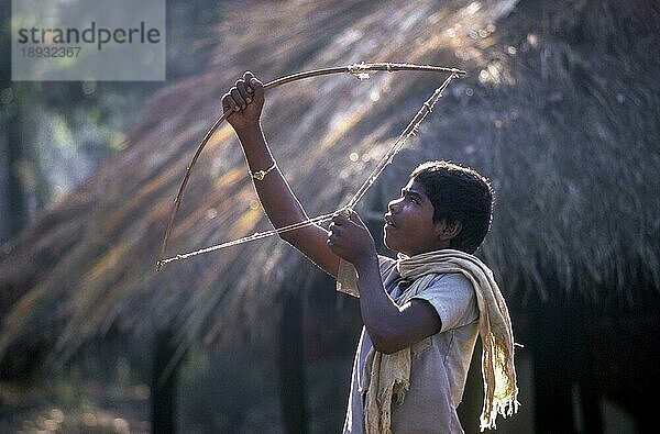 Jenu Kurumba Stammesjunge beim Zielen mit einem Stein  Nagarahole  Karnataka  Südindien  Indien  Asien