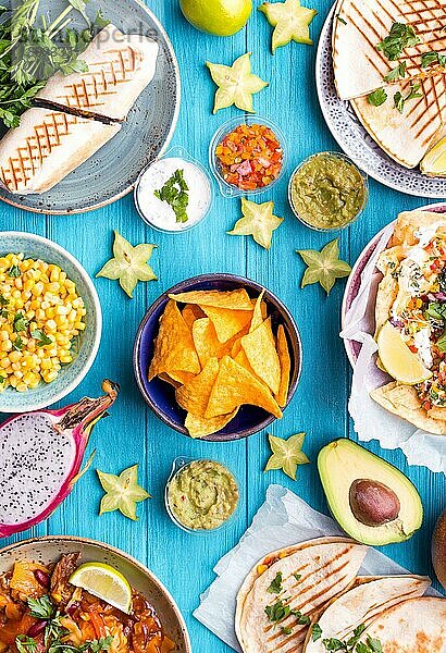 Gemischte Mischung aus traditionellen mexikanischen Gerichten. Verschiedene mexikanische Gerichte auf dem Tisch. Käsenachos  Tacos  Guacamole  Quesadilla  Burrito  Fajitas  Tortilla-Chips  mexikanische Früchte. Tex-Mex-Küche. Mexikanischer Stil