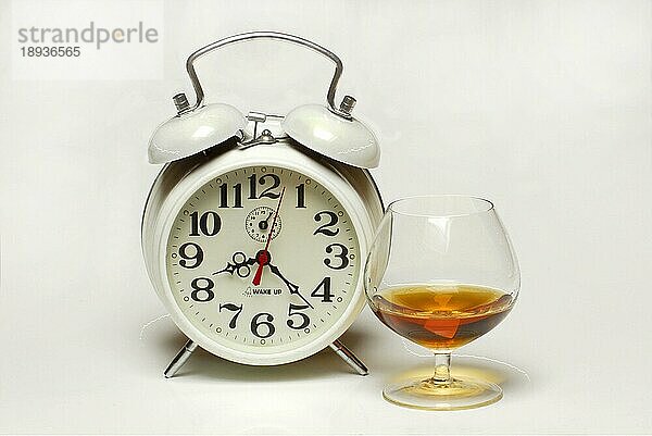 Wecker und Glas Cognac  Uhrzeit  Zeit  Alkoholproblem