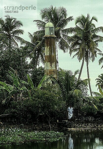 Der jahrhundertealte Leuchtturm in den Pallom Pazhukkanila Backwaters liegt südlich von Kottayam und wurde 1813 n. Chr. vom britischen Residenten von Travancore  Oberst Munroe  errichtet. D. vom britischen Residenten von Travancore  Col. Munroe  errichtet. Der Leuchtturm  der als architektonisches Wunderwerk gilt  steht noch immer unversehrt und bietet einen hervorragenden Blick auf die üppig grünen Reisfelder und die sich wiegenden Kokospalmen  Kerala  Südindien  Indien  Asien