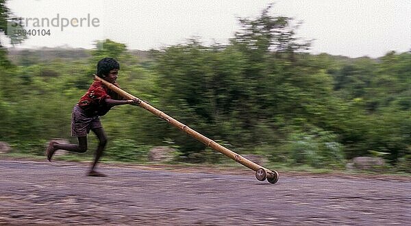 Stammesjunge spielt improvisierten Flaschenzug in Balle  Kabini  Karnataka  Südindien  Indien  Asien