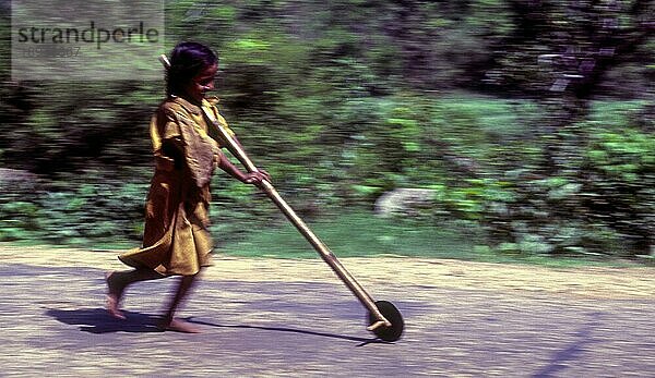 Schwenken  Stammesmädchen  das auf einem improvisierten Flaschenzug spielt  Kabini  Karnataka  Südindien  Indien  Asien