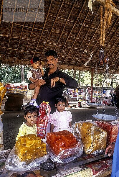 Ein Mann mit Kindern kauft Halwa  Süßigkeiten in einem Geschäft  Palakkad  Kerala  Indien  Asien