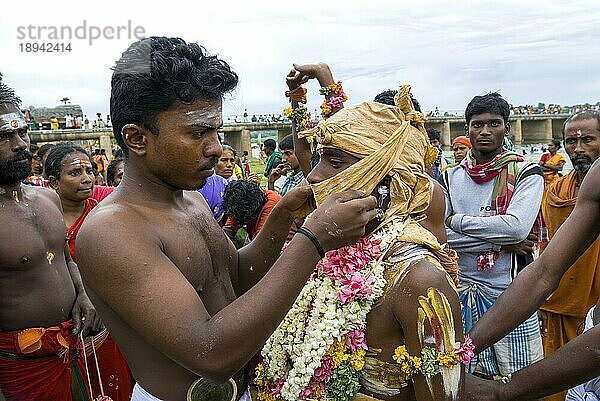 Ein Mann bindet ein Stück Stoff zum Verschließen des Mundes  Vaikasi Visakam Festival in Tiruchendur  Tamil Nadu  Südindien  Indien  Asien