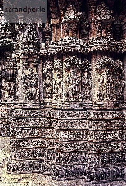 Venugopala  Keshava und Janardana mit ihren Konzerten und der Hälfte der Wandfläche mit den geschnitzten horizontalen Bindungen im Chennakesava-Tempel in Somanathapura Somnathpur  Karnataka  Südindien  Indien  Asien