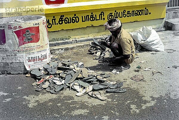 Ein Mann sammelt während des Mahamakham Mahamaham Mahamagam Festivals in Kumbakonam  Tamil Nadu  Indien  die von der Menge vermissten Chappals ein  Asien