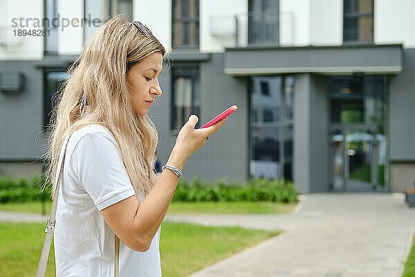 Ernste Frau  die eine Sprachnachricht auf ihrem Smartphone abhört