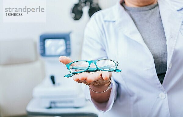 Optometrist Hände zeigen eine Brille. Augenarzt gibt Brille in Handfläche. Brillen und visuelle Gesundheit Konzept