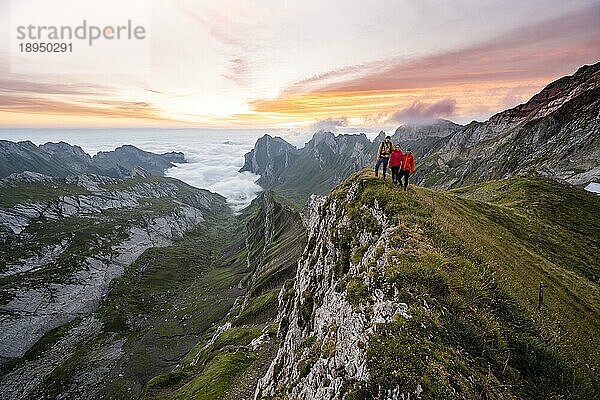 Ausblick über Säntis Gebirge ins Tal der Meglisalp bei Sonnenaufgang  Freunde  Bergsteiger am Rotsteinpass  Hochnebel im Tal  Säntis  Appenzell Ausserrhoden  Appenzeller Alpen  Schweiz  Europa