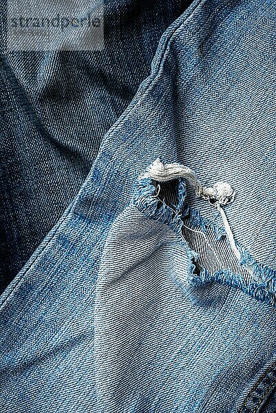 Detail einer Blue Jeans Textur mit Riss. Freier Raum für Copyspace
