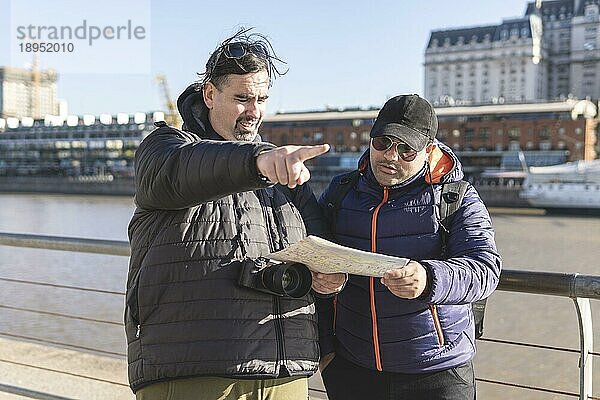 Ein paar Freunde konsultieren die Karte  während sie Puerto Madero  Buenos Aires  Argentinien  erkunden  Südamerika