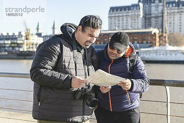 Ein paar Freunde konsultieren die Karte  während sie Puerto Madero  Buenos Aires  Argentinien  erkunden  Südamerika