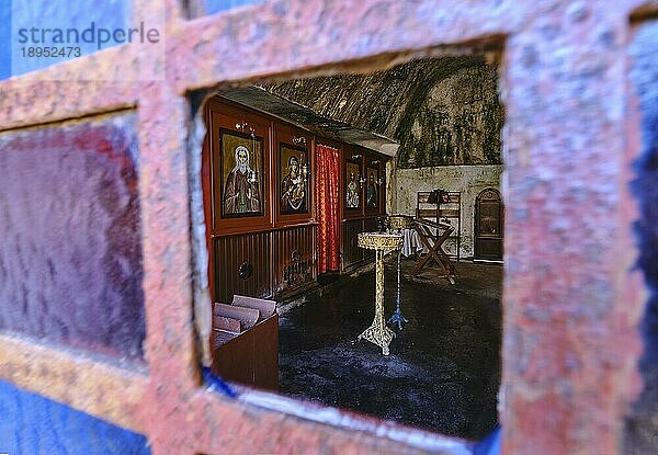 Das Innere der orthodoxen Höhlenkirche des Heiligen Johannes des Einsiedlers im verlassenen Kloster Katholiko in der Avlaki Schlucht auf der Halbinsel Akrotiri  Chania  Kreta  Griechenland. Aufnahme durch ein offenes Fenster. Selektiver Fokus