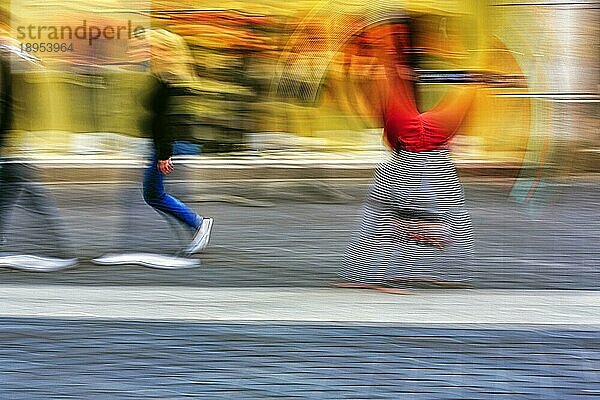 Bunter Clown schlägt ein Rad  turnt  Radschlag  Passanten in der Fußgängerzone  Symbolbild Freude  Lebensfreude  Spontanität  spontan  Bewegungsunschärfe  Bielefeld  Deutschland  Europa