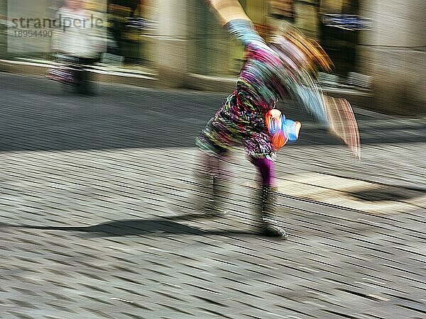 Bunter Clown schlägt ein Rad  turnt  Radschlag  Symbolbild Freude  Spontanität  spontan  Mut  Bewegungsunschärfe  Fußgängerzone in Bielefeld  Deutschland  Europa