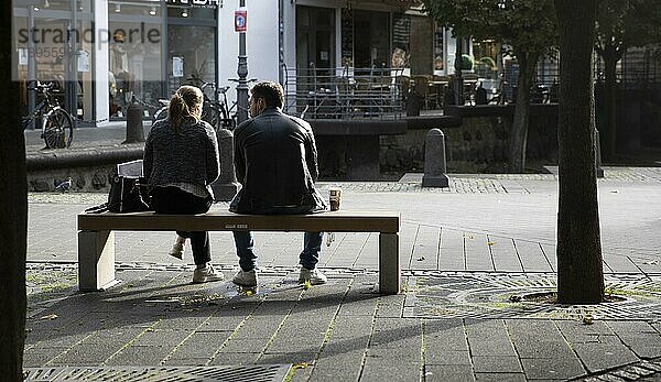 Junges Paar auf einer Parkbank in der Innenstadt  Deutschland  Europa