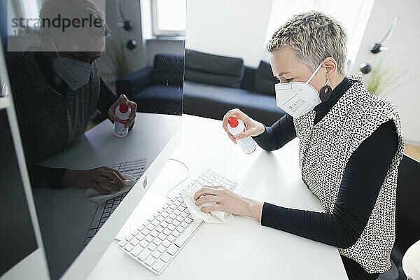 Hygiene am Arbeitsplatz. Eine Frau desinfiziert die Tastatur an ihrem Arbeitsplatz mit Desinfektionsspray. Berlin  04.11.2020  Berlin  Deutschland  Symbolfoto zum Thema  Europa