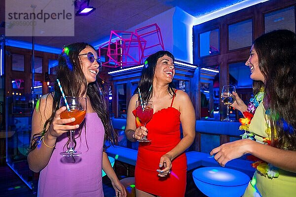 Porträt attraktive Frauen in einem Nachtclub tanzen mit den Gläsern bei einer Sommernachtsparty in einer Kneipe