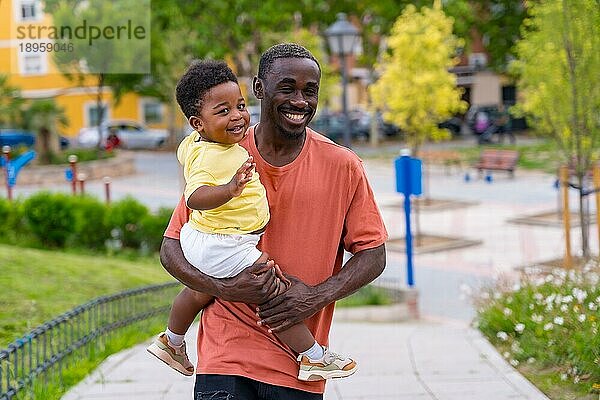 Afrikanischer schwarzer ethnischer Vater hat Spaß mit seinem Sohn auf dem Spielplatz