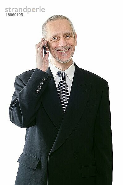Ein freundlicher Geschäftsmann lächelt auf seinem Mobiltelefon