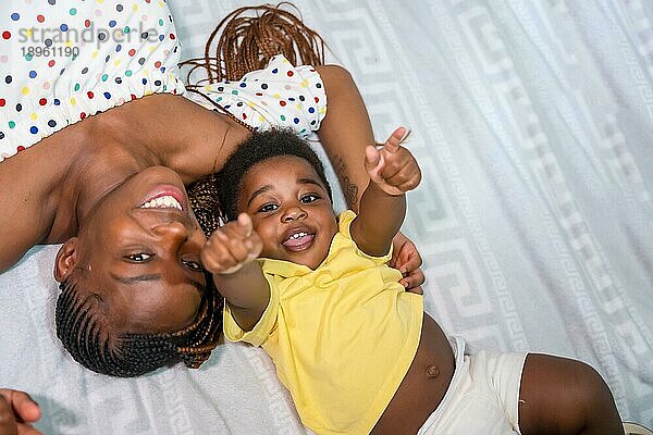 Afrikanische schwarze ethnische Familie Mutter mit ihrem kleinen Sohn im Schlafzimmer auf dem Bett lächelnd  Overhead Schuss