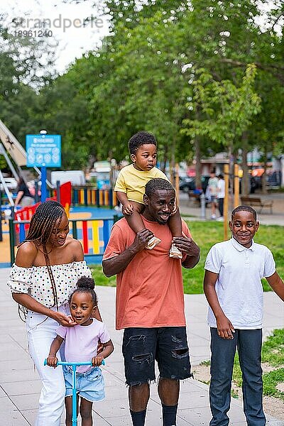 Porträt einer afrikanisch schwarzen ethnischen Familie mit Kindern auf dem Spielplatz eines Stadtparks