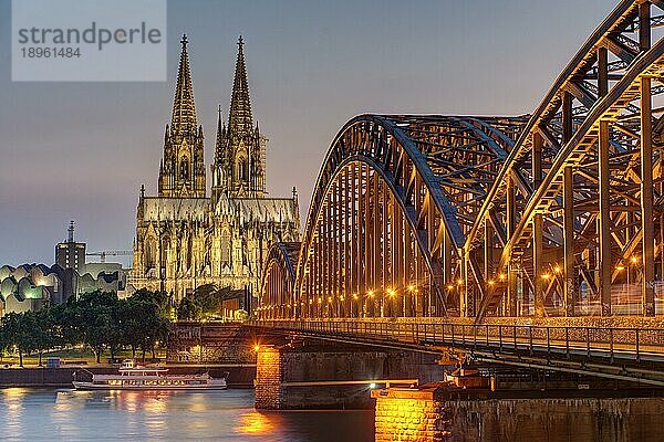 Der beeindruckende Kölner Dom und die Hohenzollernbrücke über den Rhein nach Sonnenuntergang