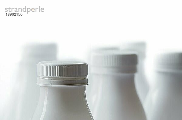 Gruppe von weißen Plastikmilchflaschen auf weißem Hintergrund