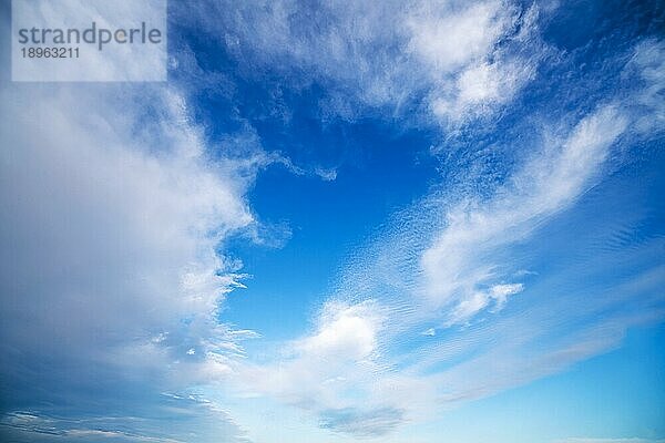 Blaür Himmel mit dramatischen weißen Wolken an einem hellen und windigen Tag