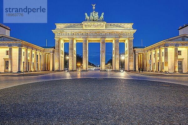 Das beleuchtete Brandenburger Tor in Berlin im Morgengrauen ohne Menschen