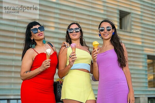 Porträt junger Freundinnen beim Eisessen im Sommerurlaub am Strand