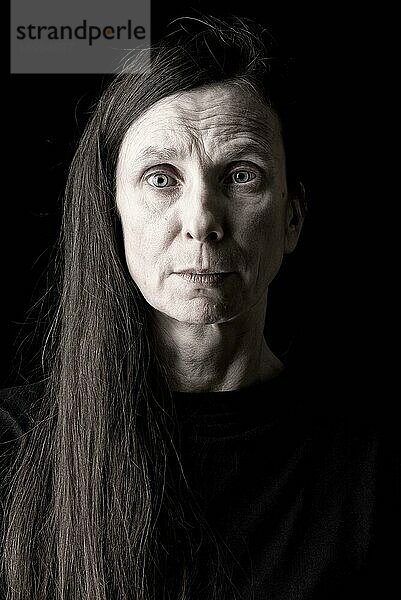 Porträt einer traurigen und deprimierten erwachsenen Frau mit langen Haaren