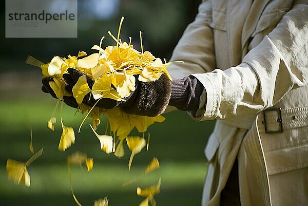 Frau hält fallende gelbe Herbstblätter
