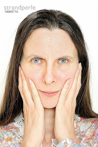 Ein wütendes Seniorinnenporträt  mit den Händen im Gesicht