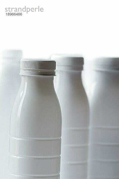 Gruppe von weißen Plastikmilchflaschen auf weißem Hintergrund