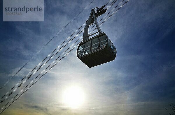 Seilbahn im Gegenlicht mit Wolken und blauem Himmel in der Schweiz