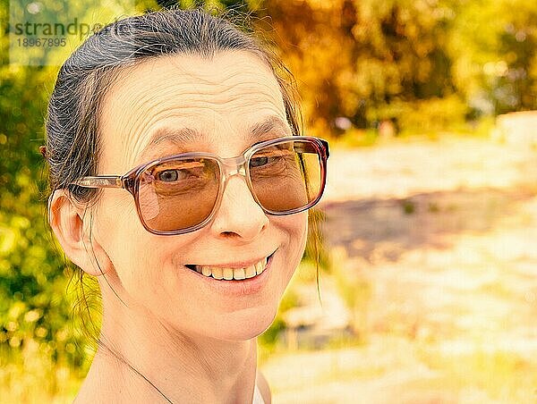 Snapshop einer lächelnden kaukasischen erwachsenen Frau mit großer Sonnenbrille im Vintagestil