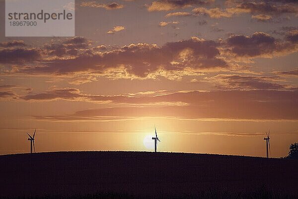 Windmühlen Silhouetten auf einem Hügel in einem schönen Sonnenuntergang mit dramatischen Himmel