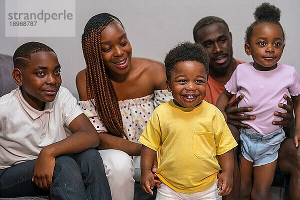 Afrikanische schwarze ethnische Familie mit Kindern auf dem Sofa zu Hause  Porträt eines lächelnden Kindes