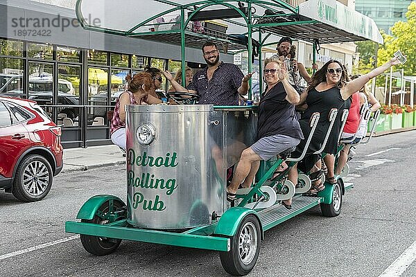 Detroit  Michigan  Fröhliche Feiernde auf einem Pedal Pub in der Innenstadt von Detroit. Die Gesetze des Bundesstaates und der Stadt erlauben es Gruppen  ihre eigenen alkoholischen Getränke auf Tretkneipen zu konsumieren