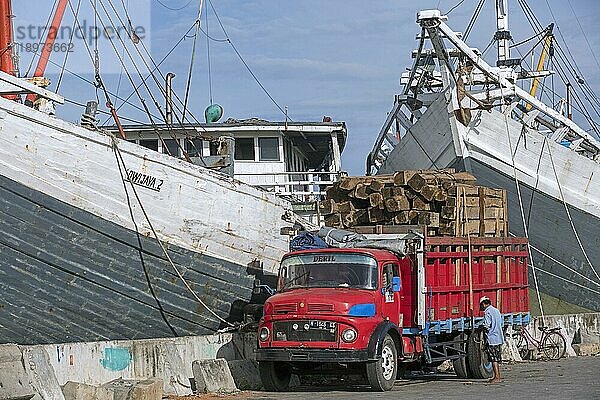 Mit Holz beladener Lastwagen vor hölzernen pinisis  phinisis  traditionellen indonesischen Frachtschiffen im Hafen von Semarang  Zentraljava  Indonesien  Asien