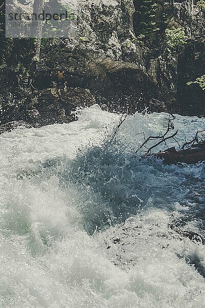 Wilder Flusslauf mit plätscherndem Wasser in einem Gebirgsbach