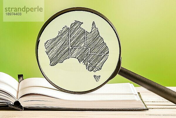 Australien Informationen mit einer Bleistiftzeichnung einer australischen Landkarte in einem Vergrößerungsglas