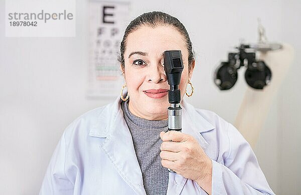 Porträt einer Optometristin mit Ophthalmoskop im Labor. Lächelnder Augenarzt  der ein Ophthalmoskop im Labor hält