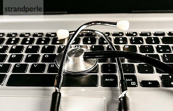 Konzept einer medizinischen Online Konsultation. Stethoskop auf Laptoptastatur