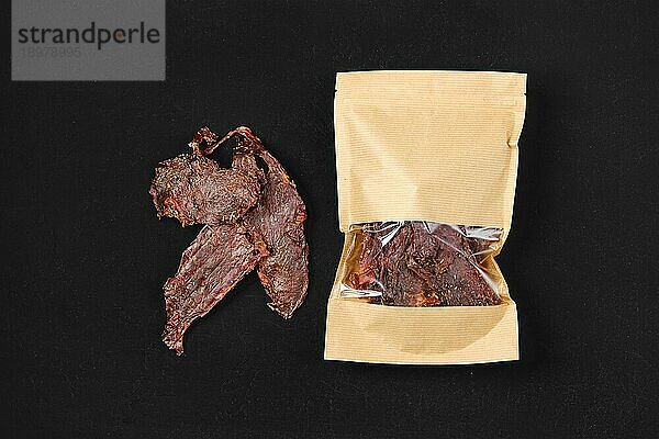 Draufsicht auf getrocknetes Beef Jerky Fleisch in Papierverpackung