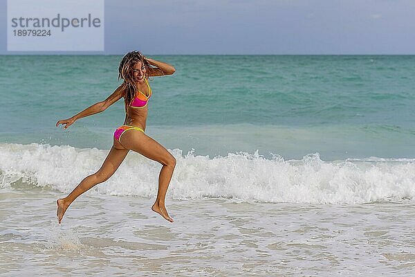 Ein schönes hispanisches brünettes Modell genießt einen Tag am Strand