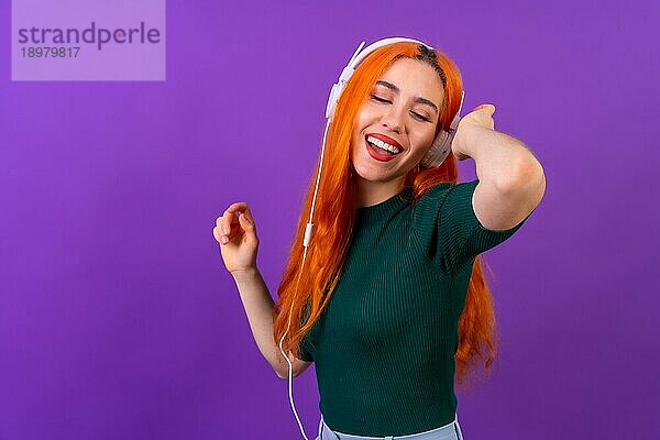 Rothaarige Frau im Studio Fotografie lächelnd tanzen auf einem lila Hintergrund